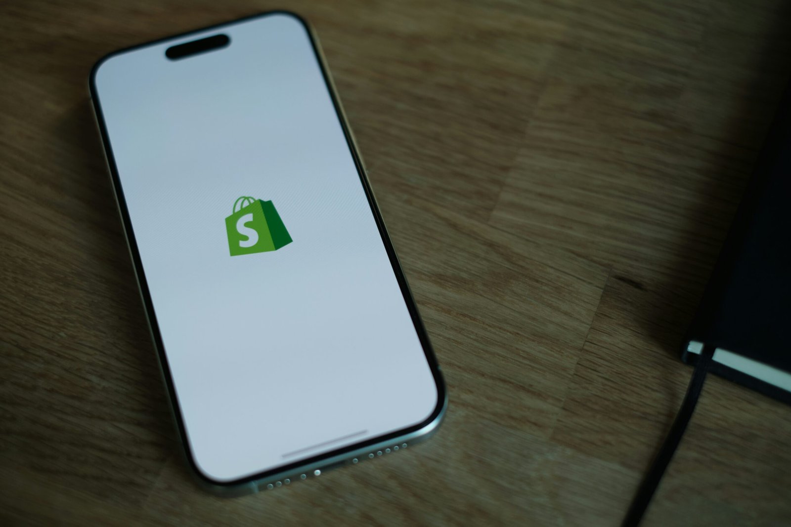 Smartphone displaying Shopify app with SMS marketing integration for syncing customers and managing campaigns
